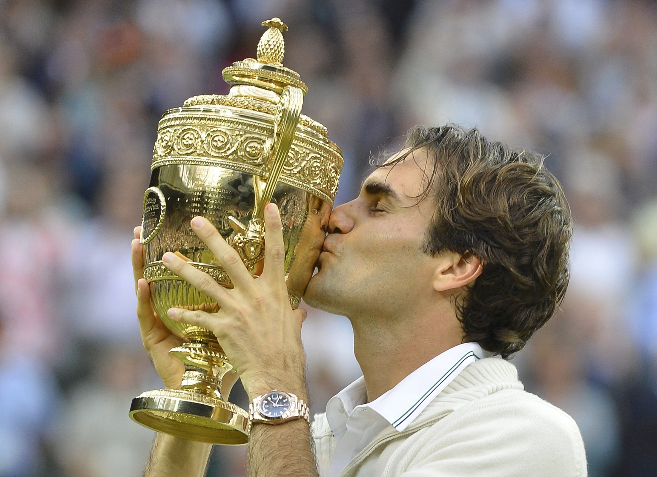 Roger Federer of Switzerland kisses the winners trophy after defeating Andy Murray of Britain in their men’s final tennis match at the Wimbledon Tennis Championships in London